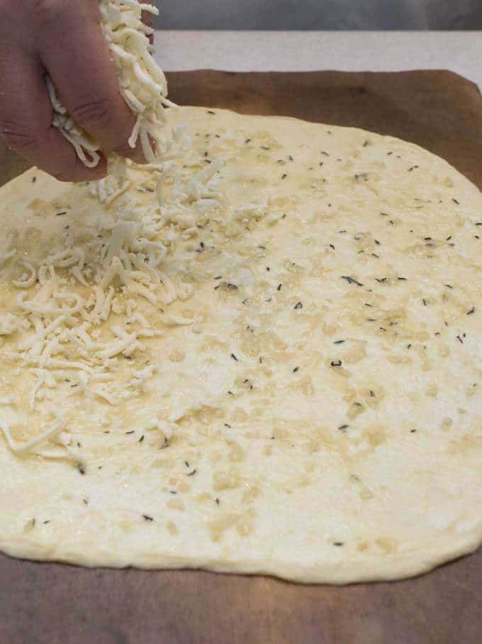 Sprinkling Mozzarella Cheese on Pizza Dough