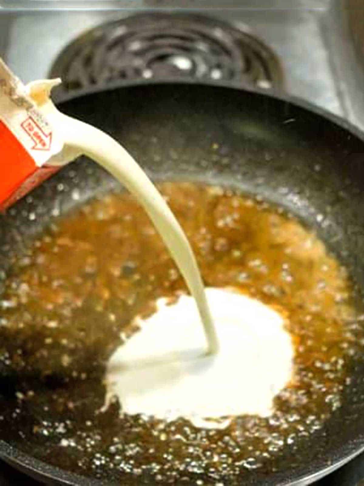 Adding cream to the reduced liquid.