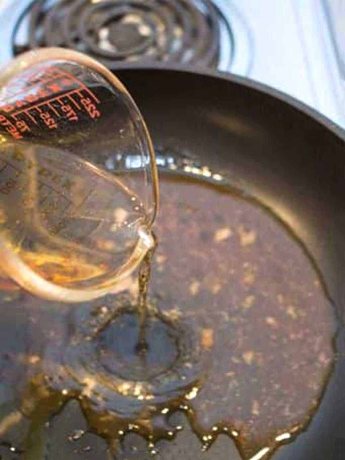 Adding vinegar to the pan juices from the roast.