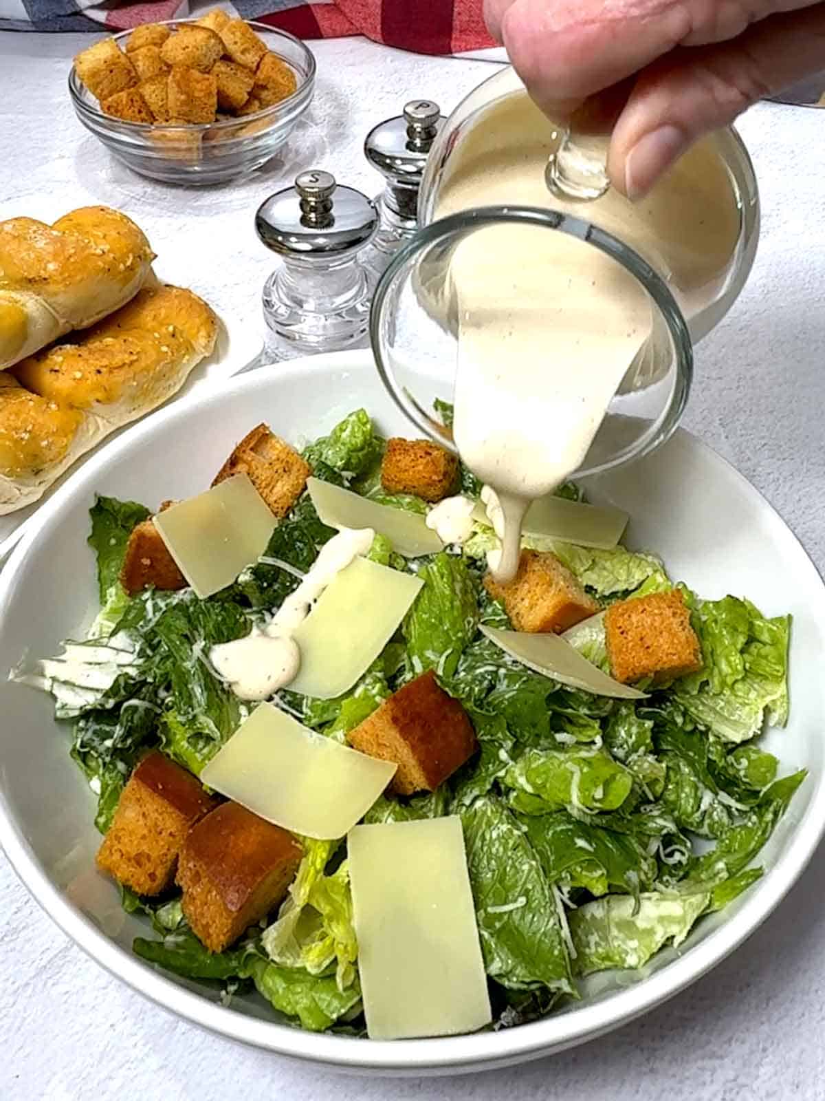 Adding additional dressing to the salad.