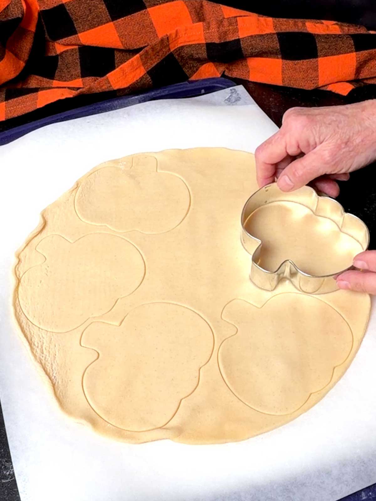 Cutting the pumpkin shapes with a cookie cutter.