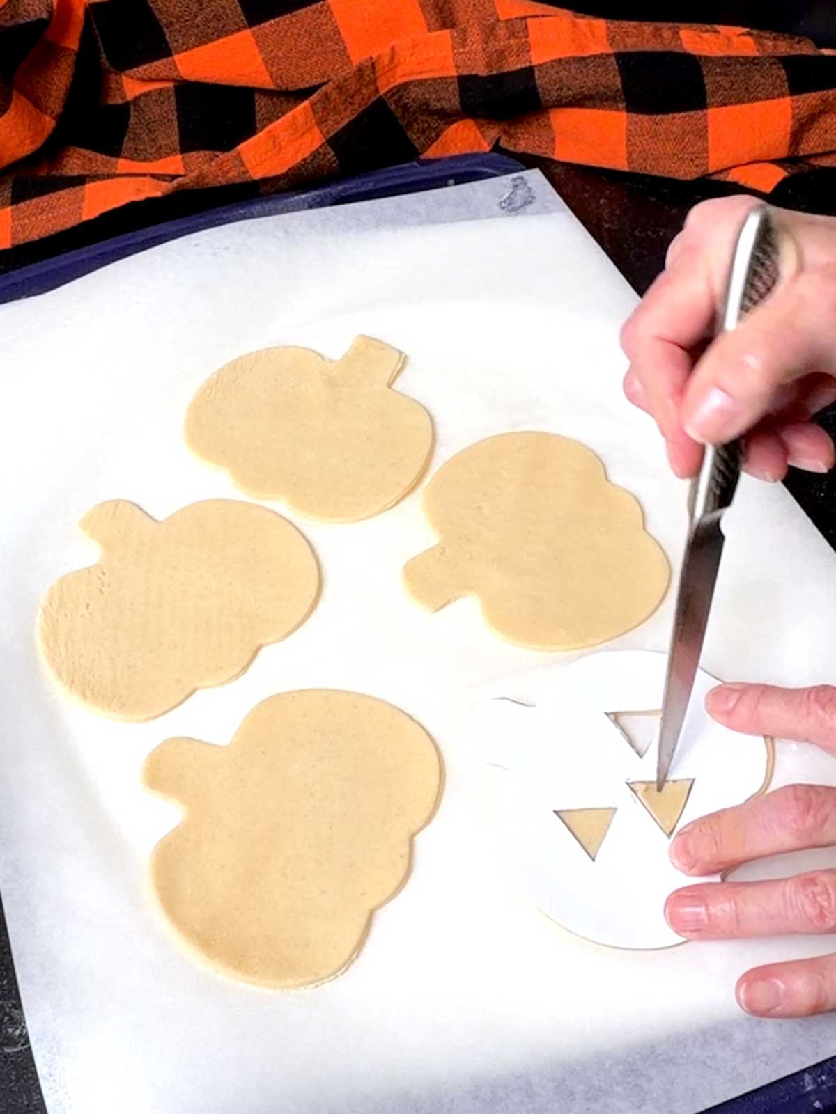 Cutting the pumpkin faces with a sharp knife.