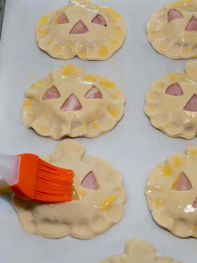 Brushing the top of the hand pies with egg wash
