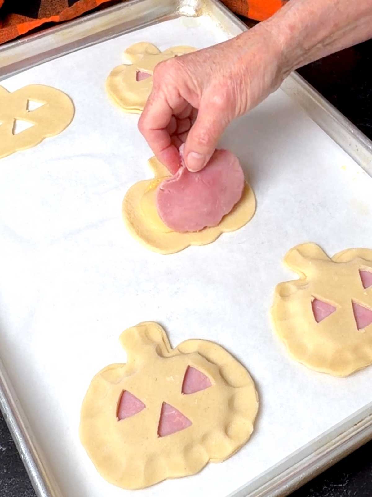 Placing ham on the pumpkin cutout.