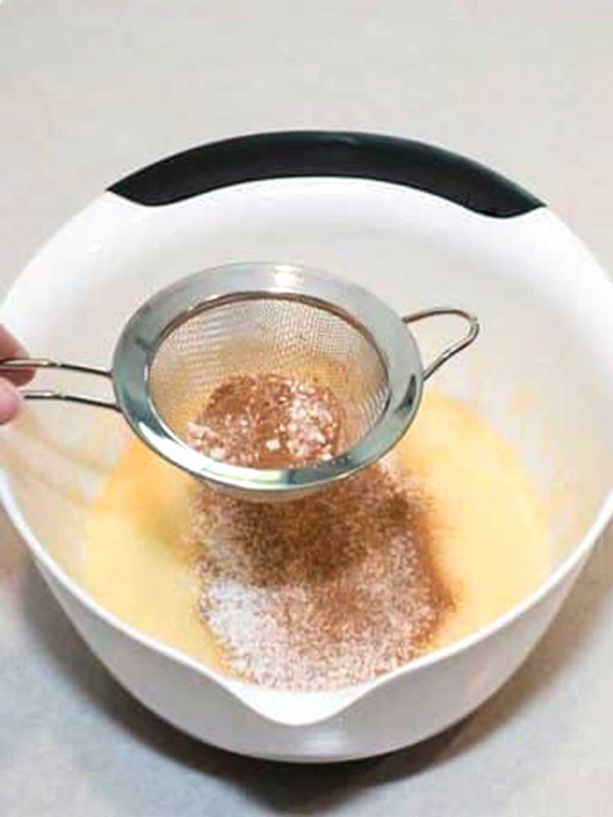 Sifting the spices and baking soda.