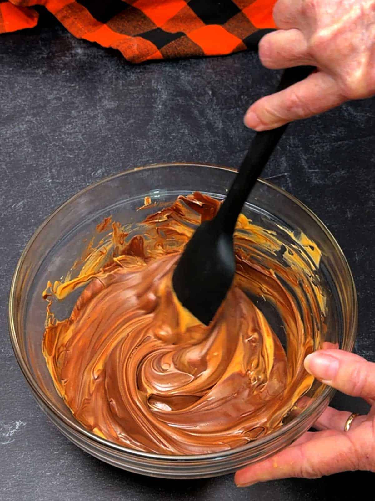 Stirring the melted chocolate and butterscotch chips.