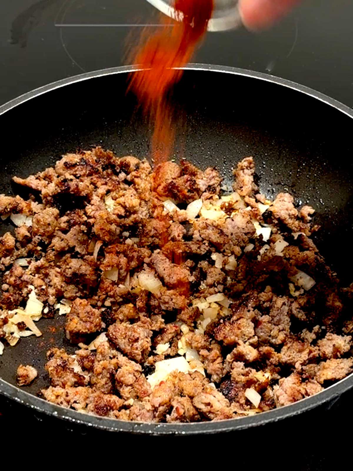 Adding paprika to the sausage and onion.