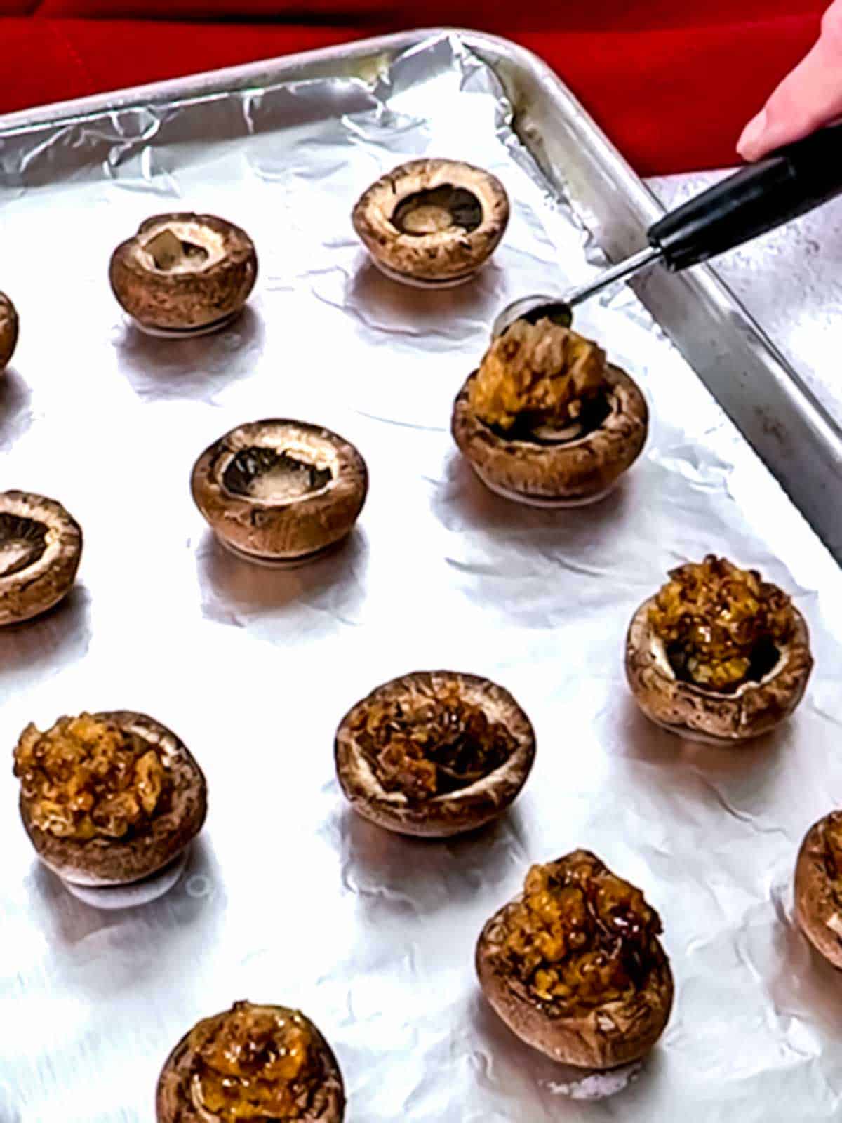 Placing the stuffing into the mushroom caps.