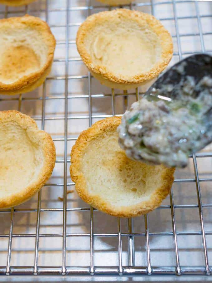 Adding the mushroom filling to the baked bread cups