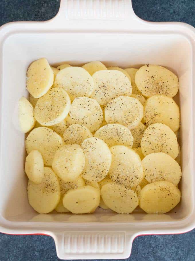 Layering the potatoes in a casserole dish.