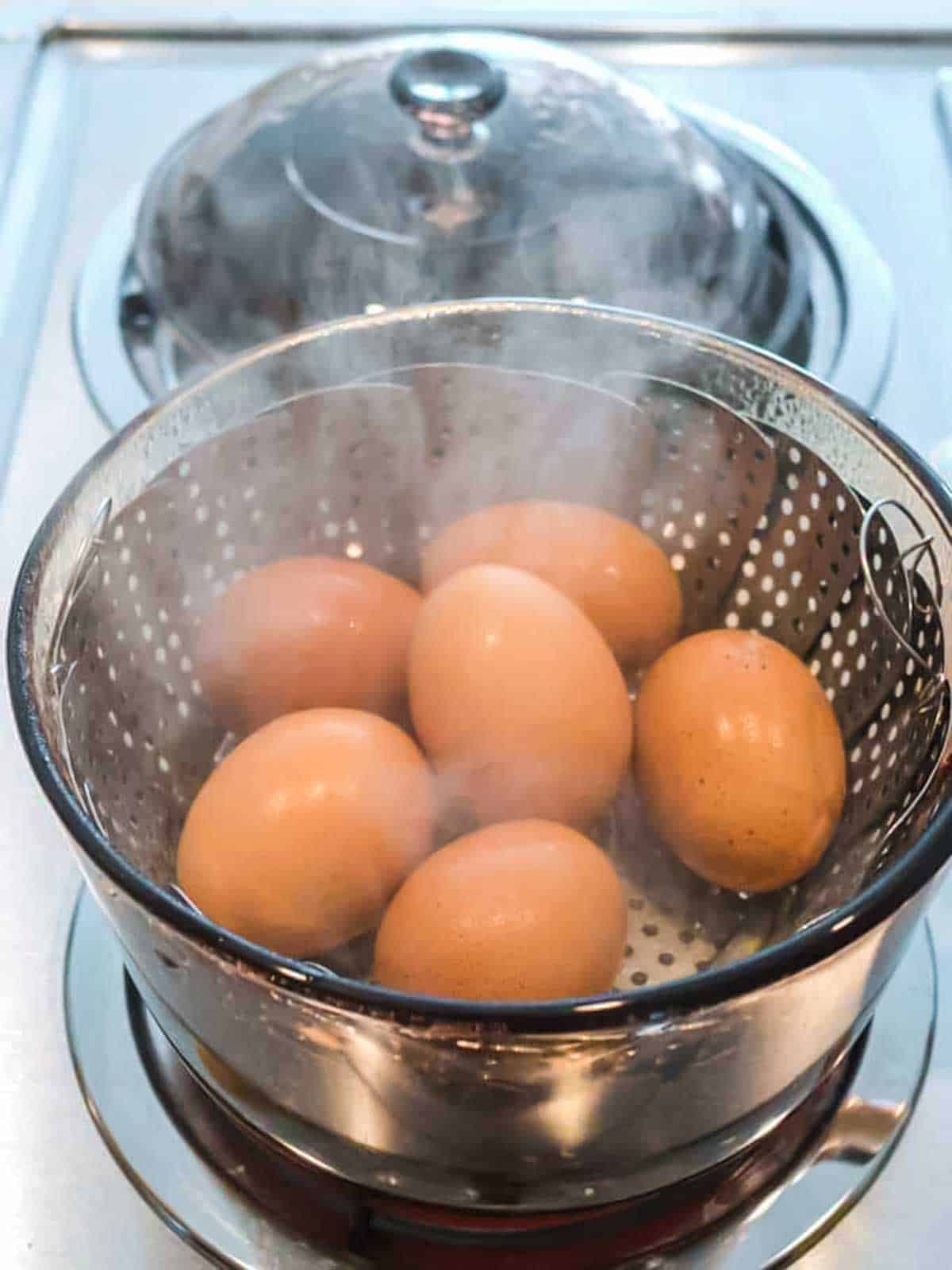 Eggs in a steamer basked on the stove.