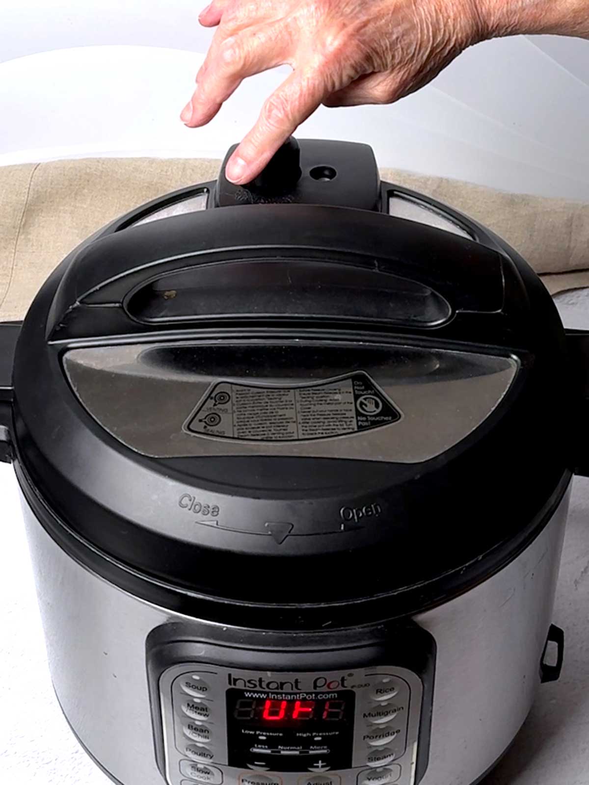 Closing the valve on the Instant Pot.
