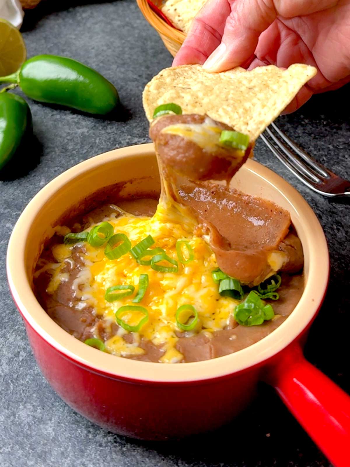 Dipping the tortilla in the smashed pinto beans.