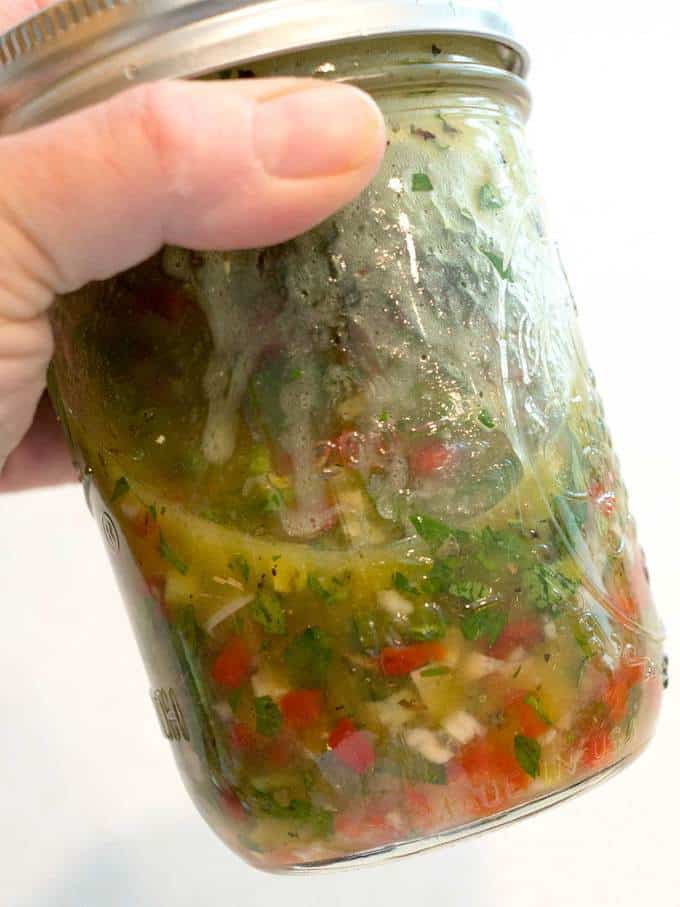 Shaking marinade ingredients in a jar with a lid.