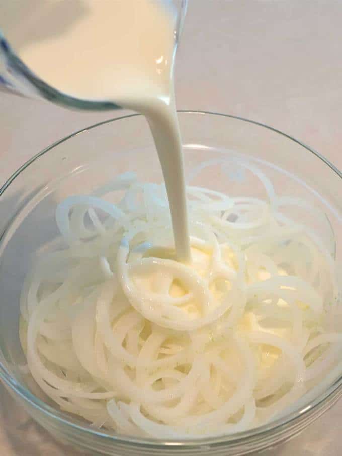 Adding buttermilk to the onion slices