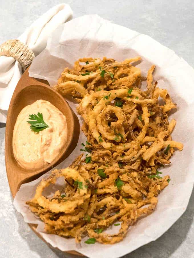 Crispy fried onion strings with homemade dipping sauce
