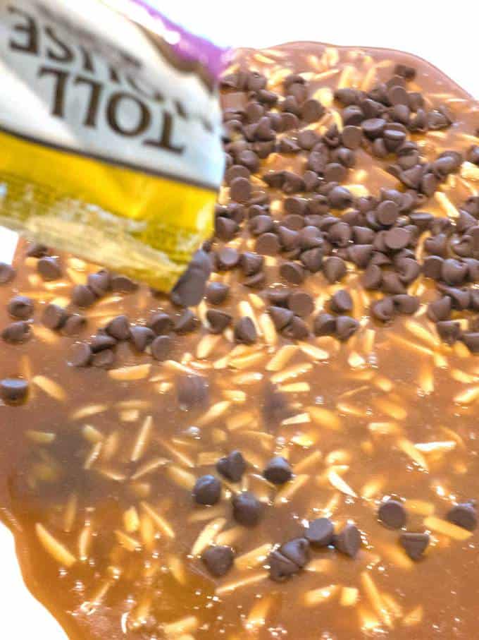Sprinkling milk chocolate chips on hot toffee