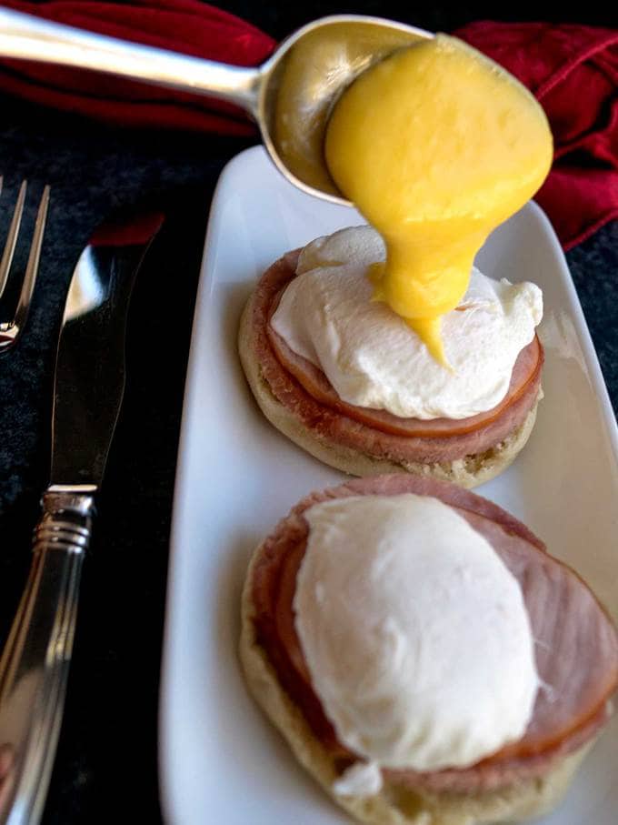 Spooning on Hollandaise Sauce for Classic Eggs Benedict