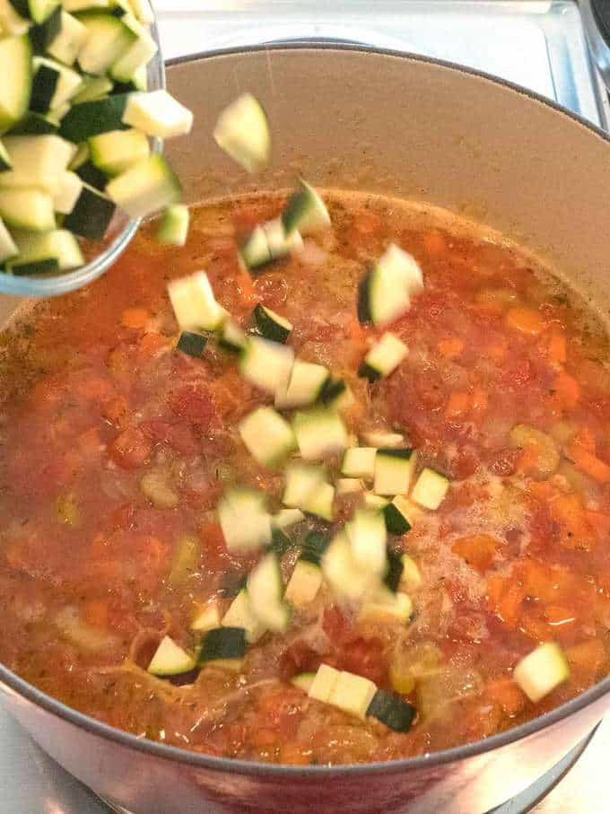 Adding the chopped zucchini to the soup