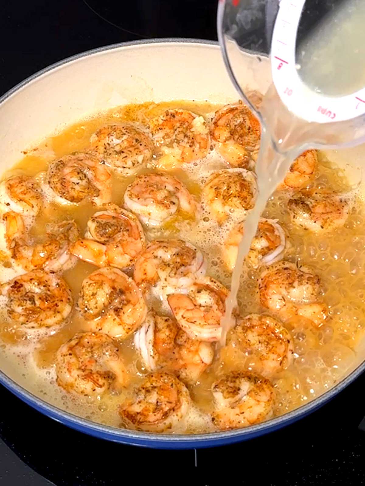 Adding lemon juice to the shrimp scampi.