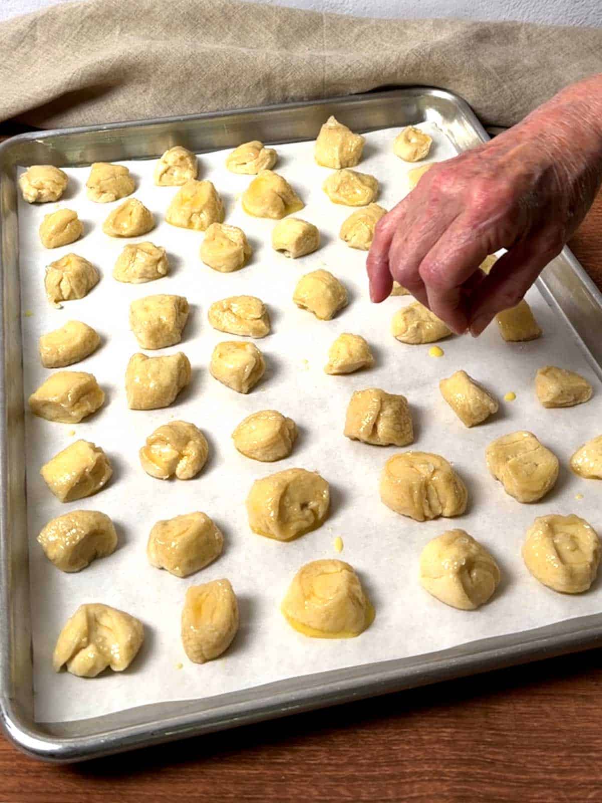 Sprinkling coarse sea salt on the pretzel bites.