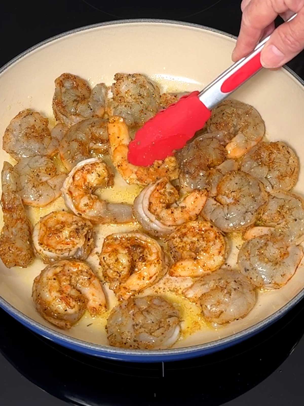 Turning the shrimp to cook on the other side.