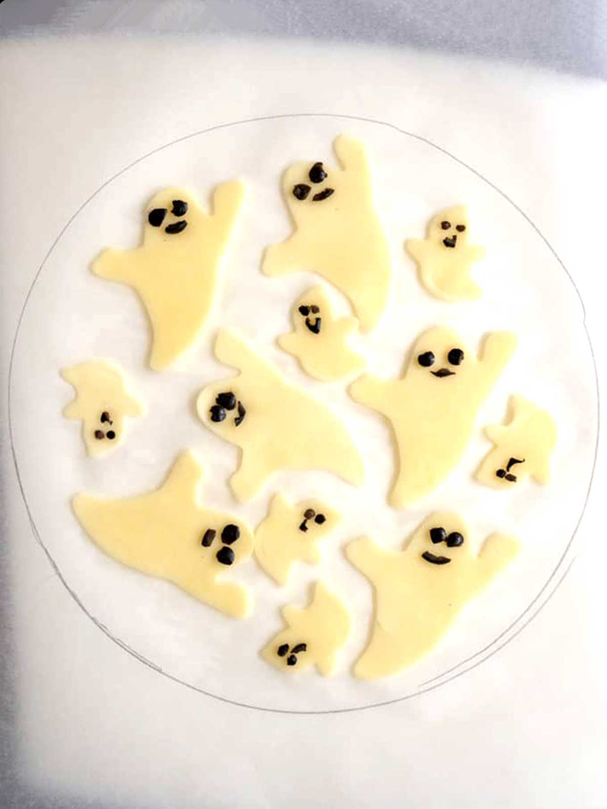 Forming the ghosts for positioning on the pizza.