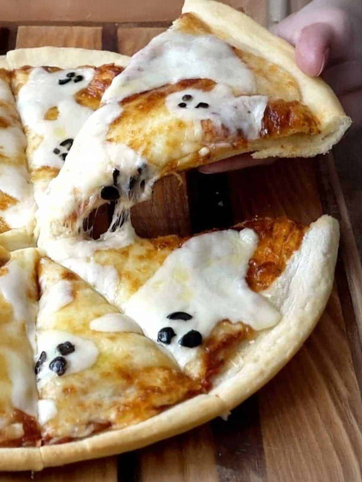 Lifting the pizza to eat.