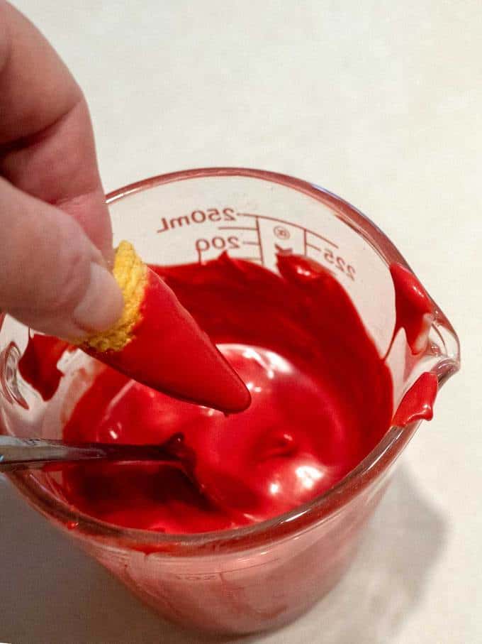 Dipping the Bugles on the melted red coating for Santa's Crunch