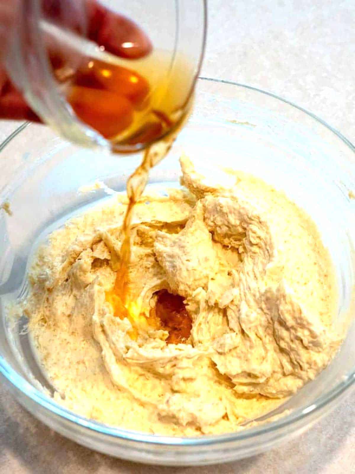 Adding vanilla extract to the butter and sugar mixture.