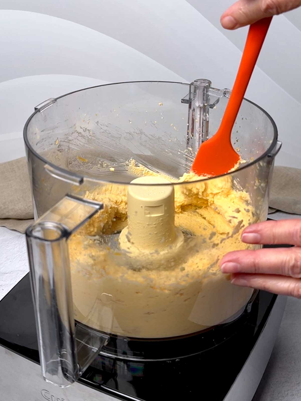 Scraping the sides of the food processor.
