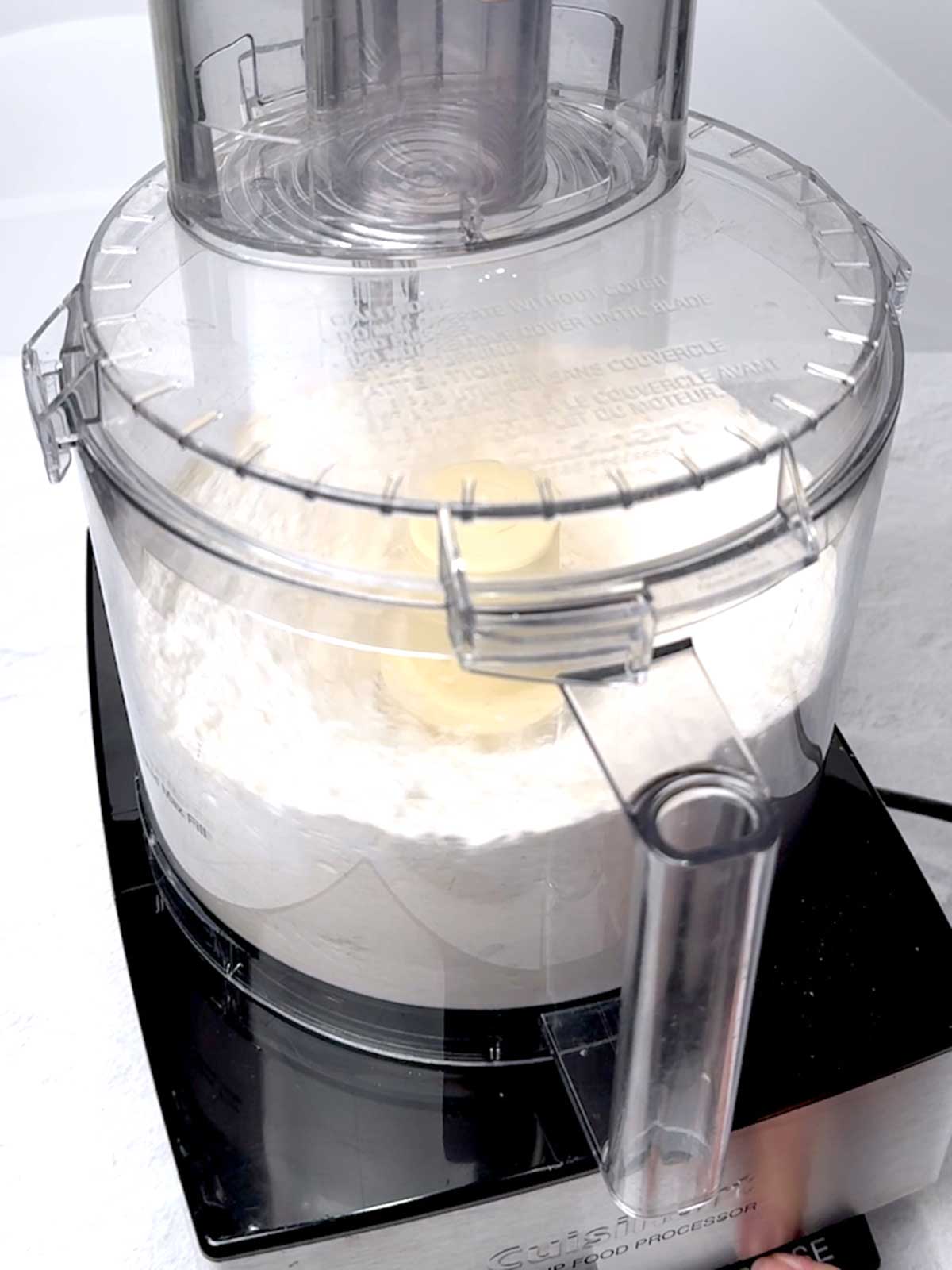 Pulsing the flour and confectioners' sugar in a food processor.