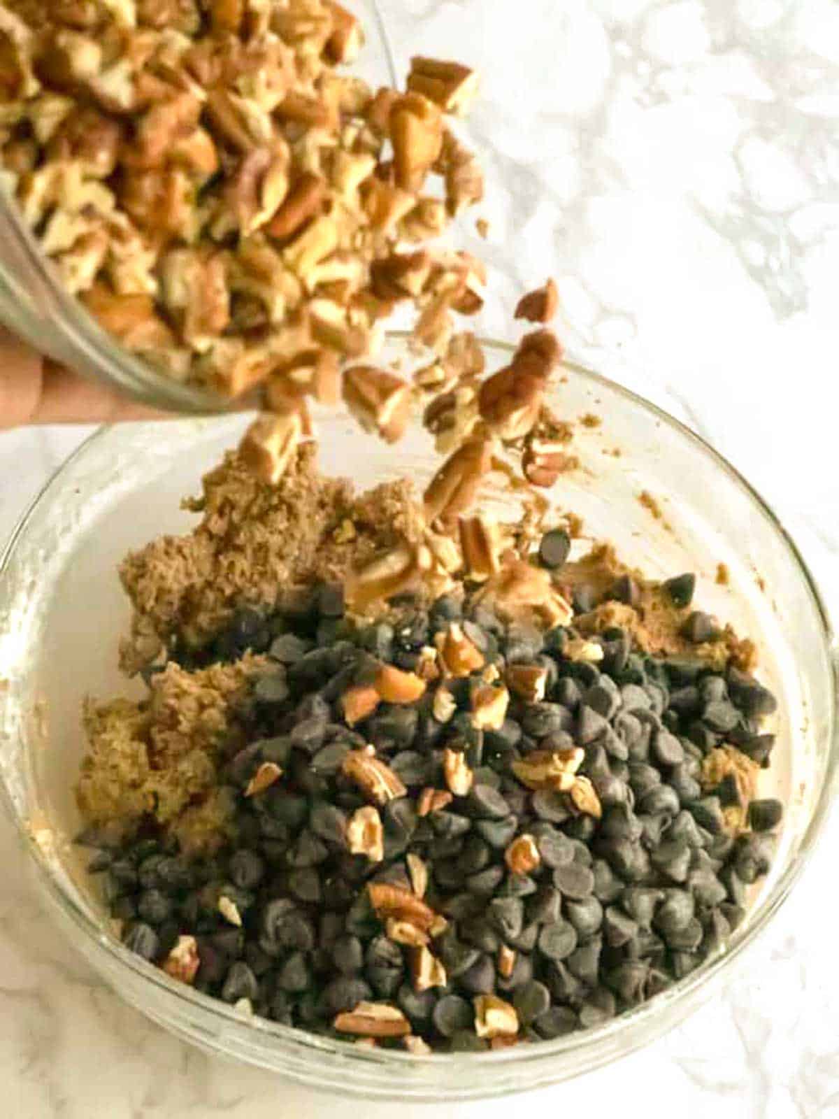 Adding pecans to the cookie dough.