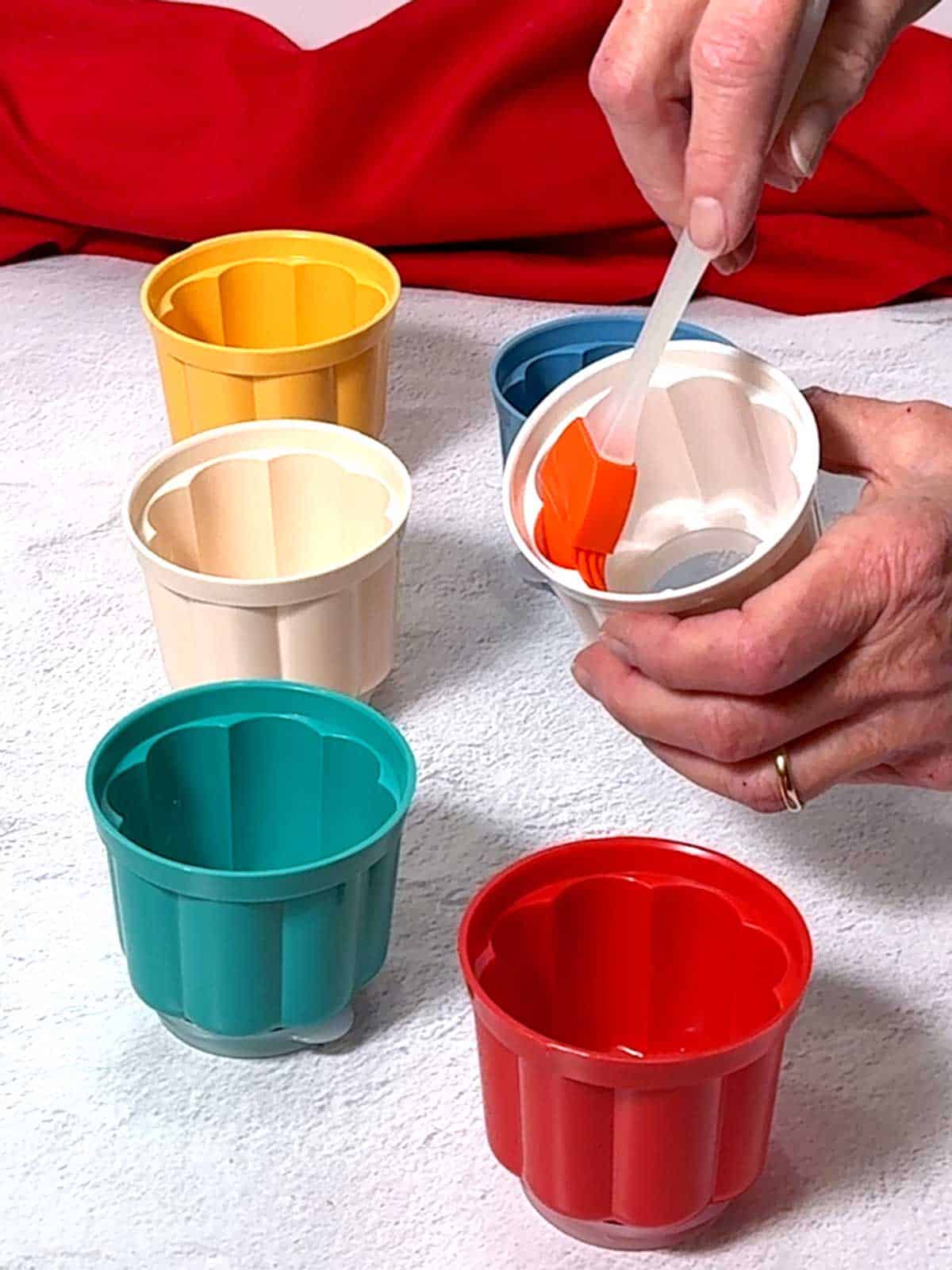 Brushing the molds for the blancmange with vegetable oil.