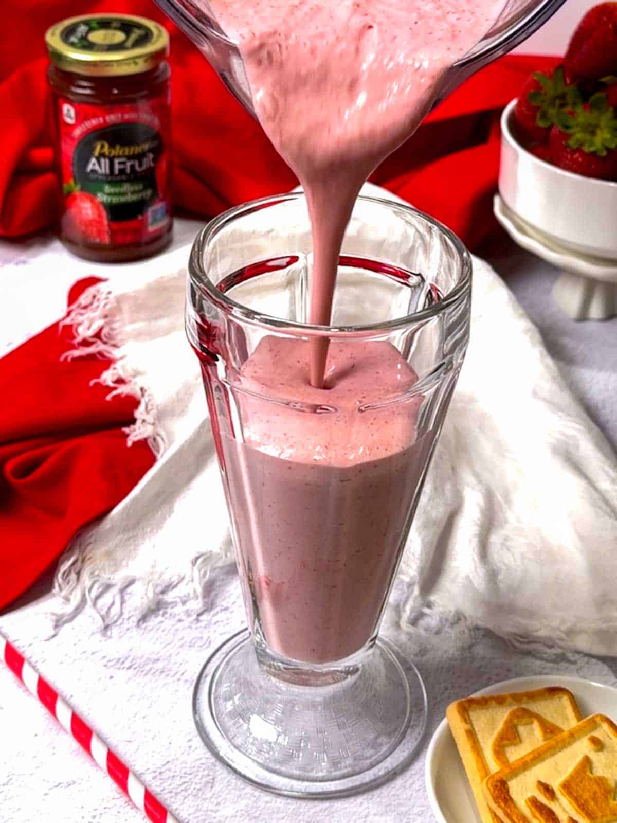Pouring the smoothie into a glass.
