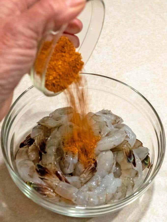 Adding Cajun seasoning to the fresh shrimp