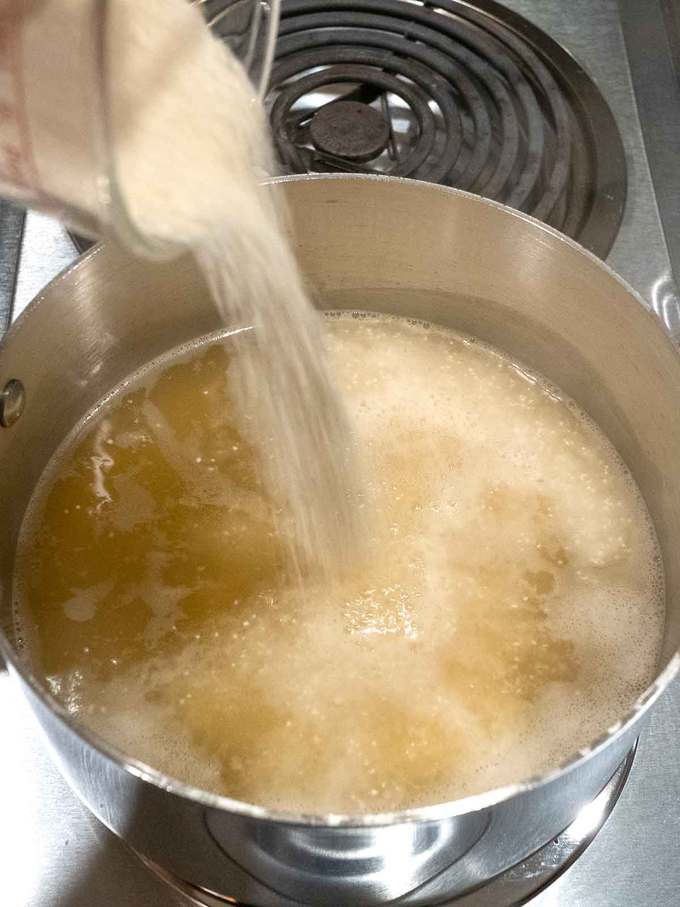 Adding the grits to boiling chicken broth