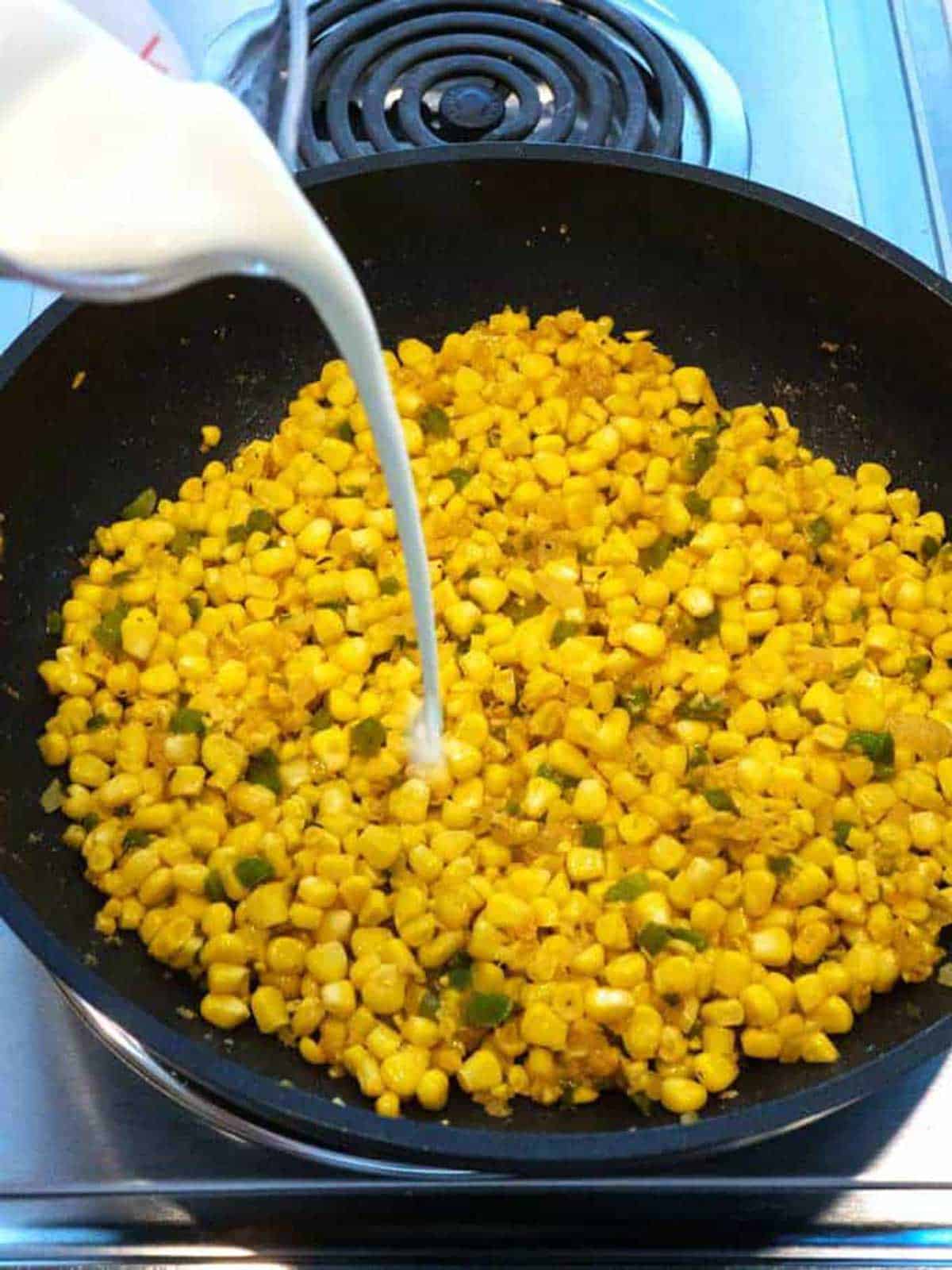 Adding cream t the corn.