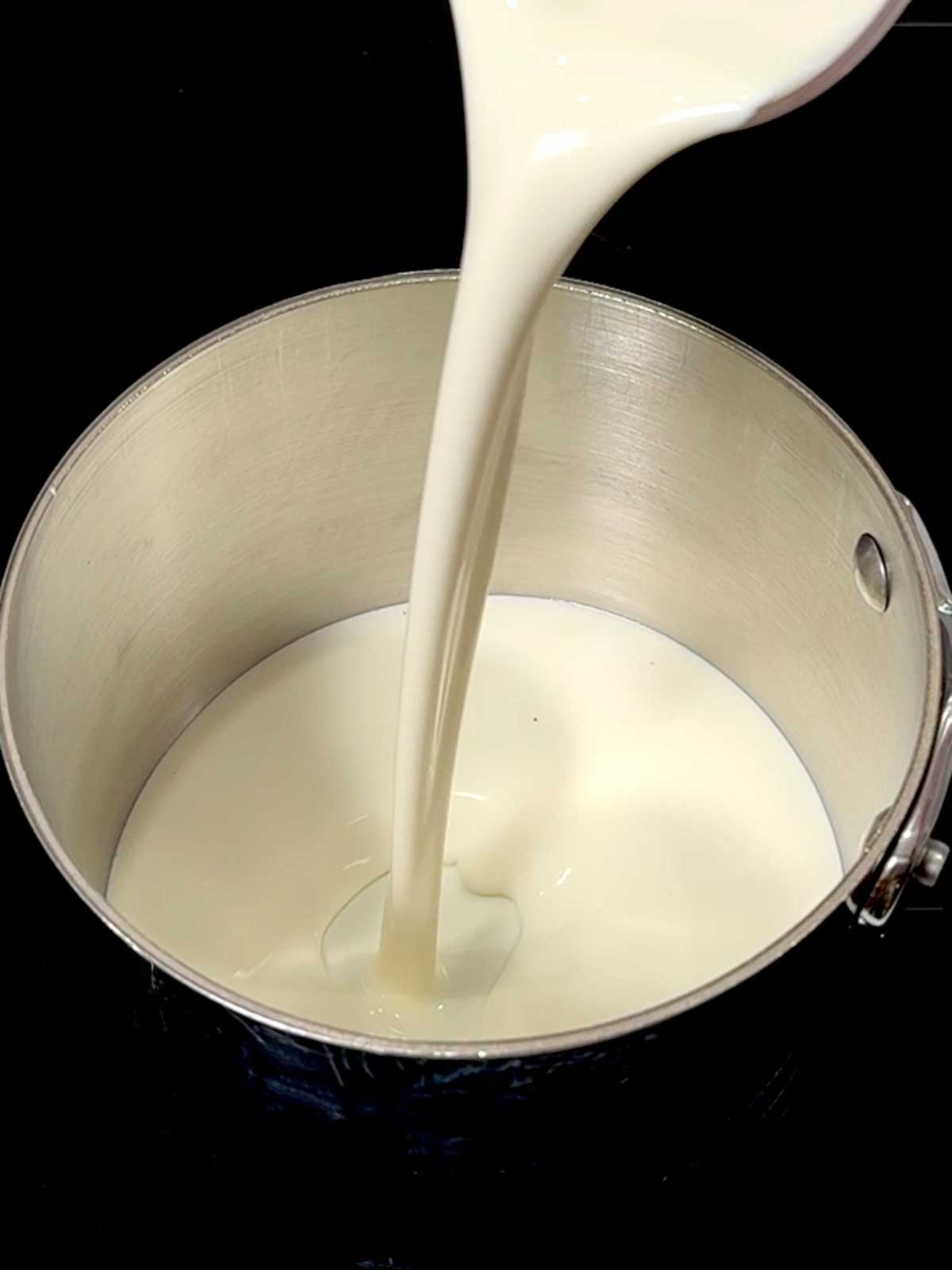 Adding cream to a saucepan.