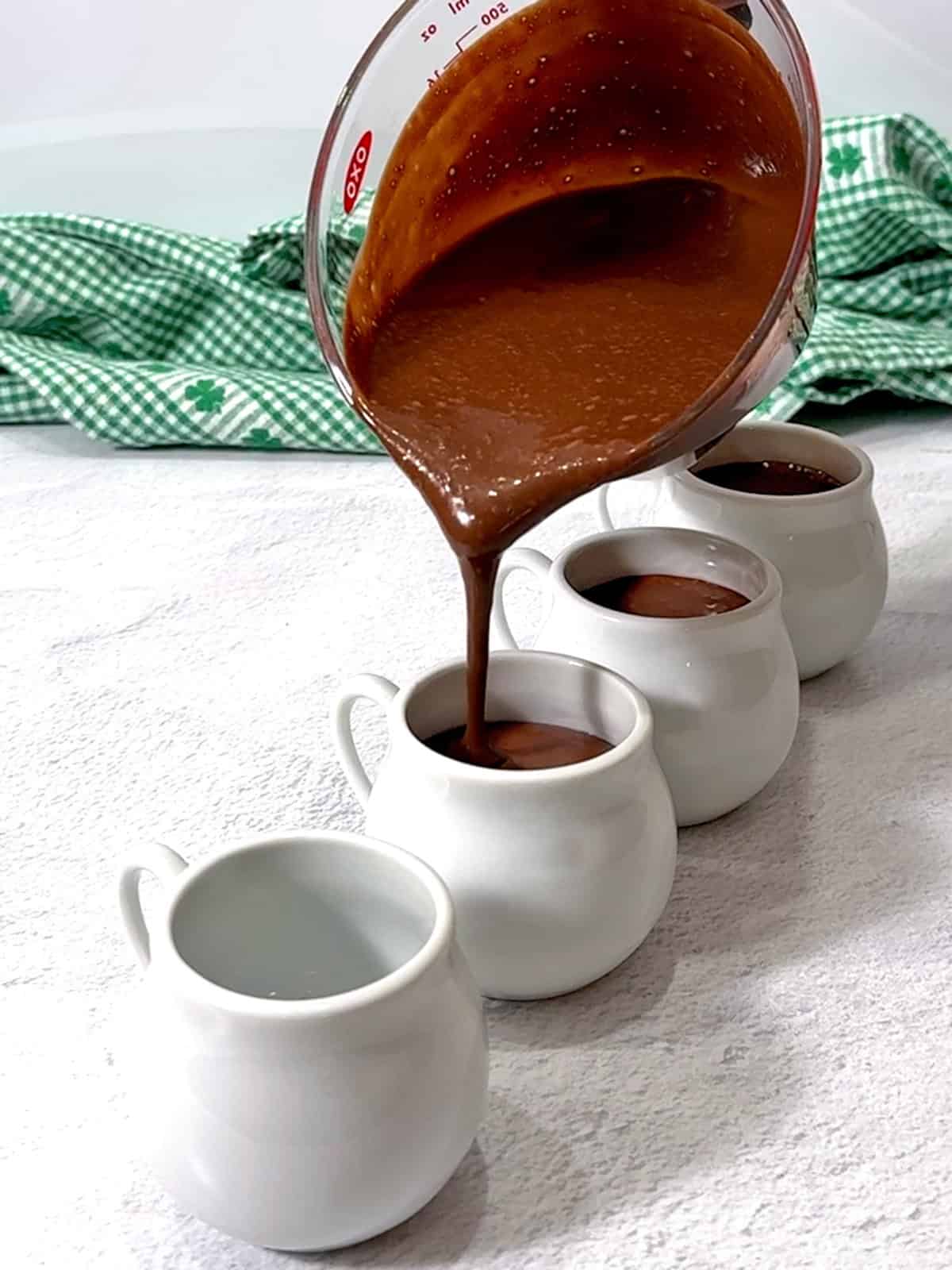 Pouring chocolate mixture into the porcelain cups.
