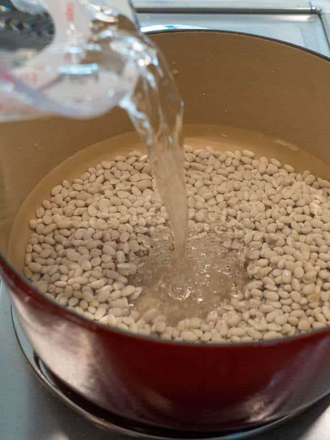 Adding filtered water to the dried beans for their quick soak