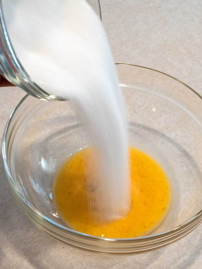 Adding sugar to beaten egg in bowl for Julia Child's Madeleines