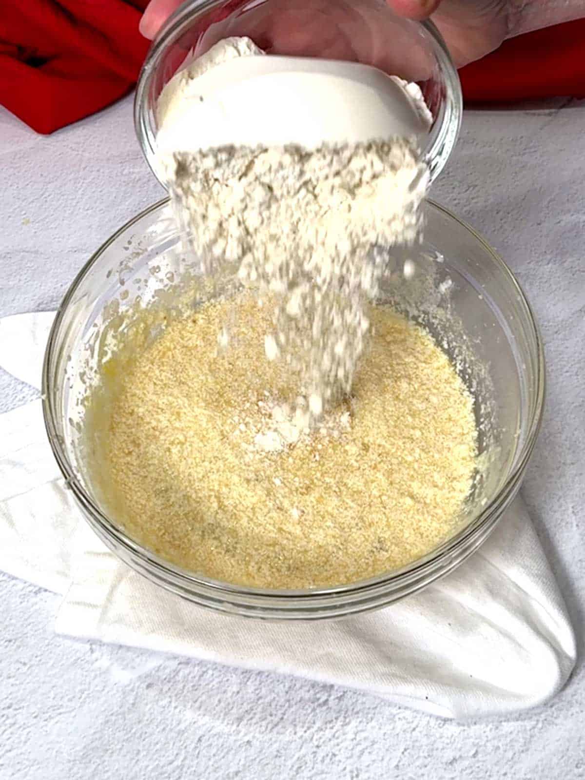 Adding flour to the bowl.