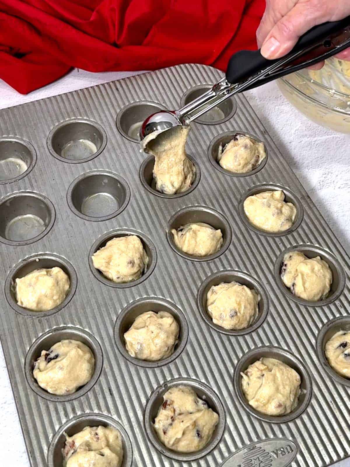 Adding the batter to the mini muffin pan.