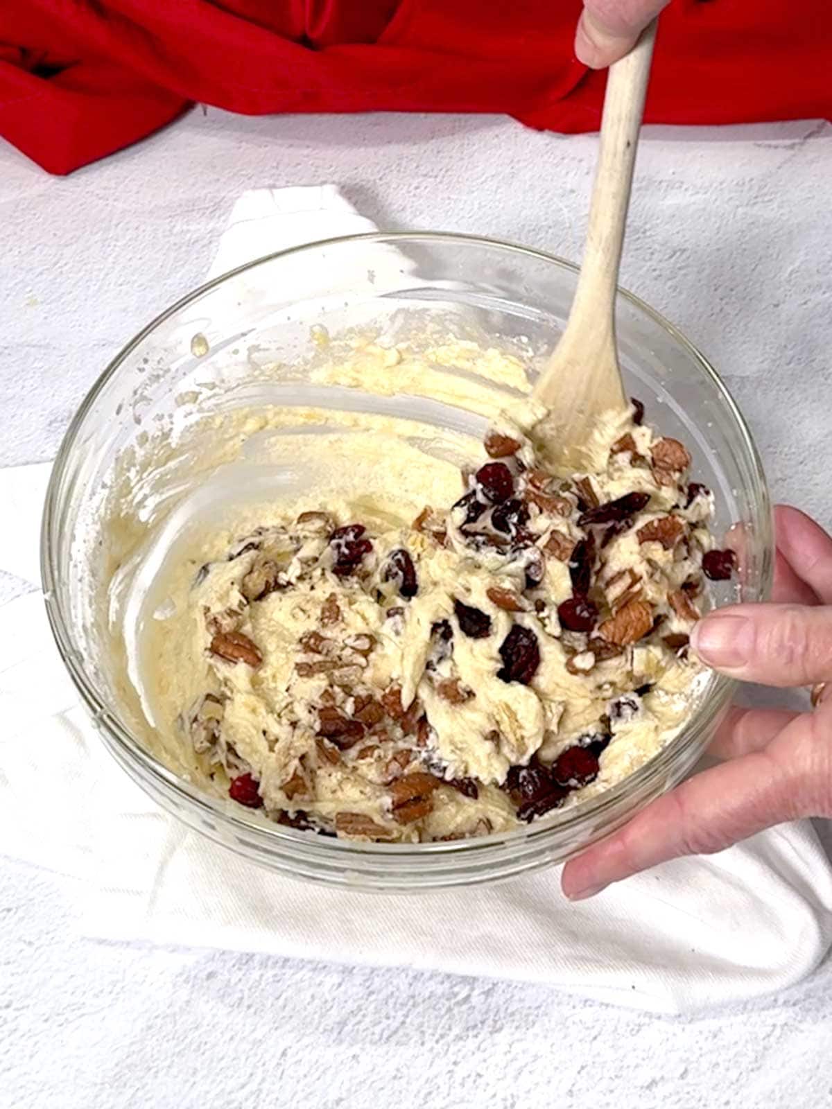 Stirring the banana Craisin mini muffin batter with a wooden spoon.