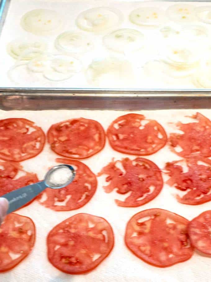 Sprinkling salt on tomato and onion slides