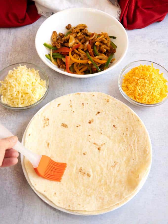 Brushing flour tortilla with oil