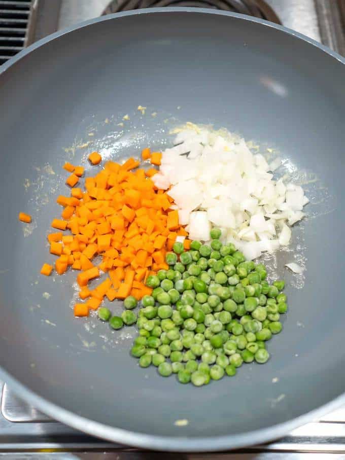 Peas, carrots and onions in wok