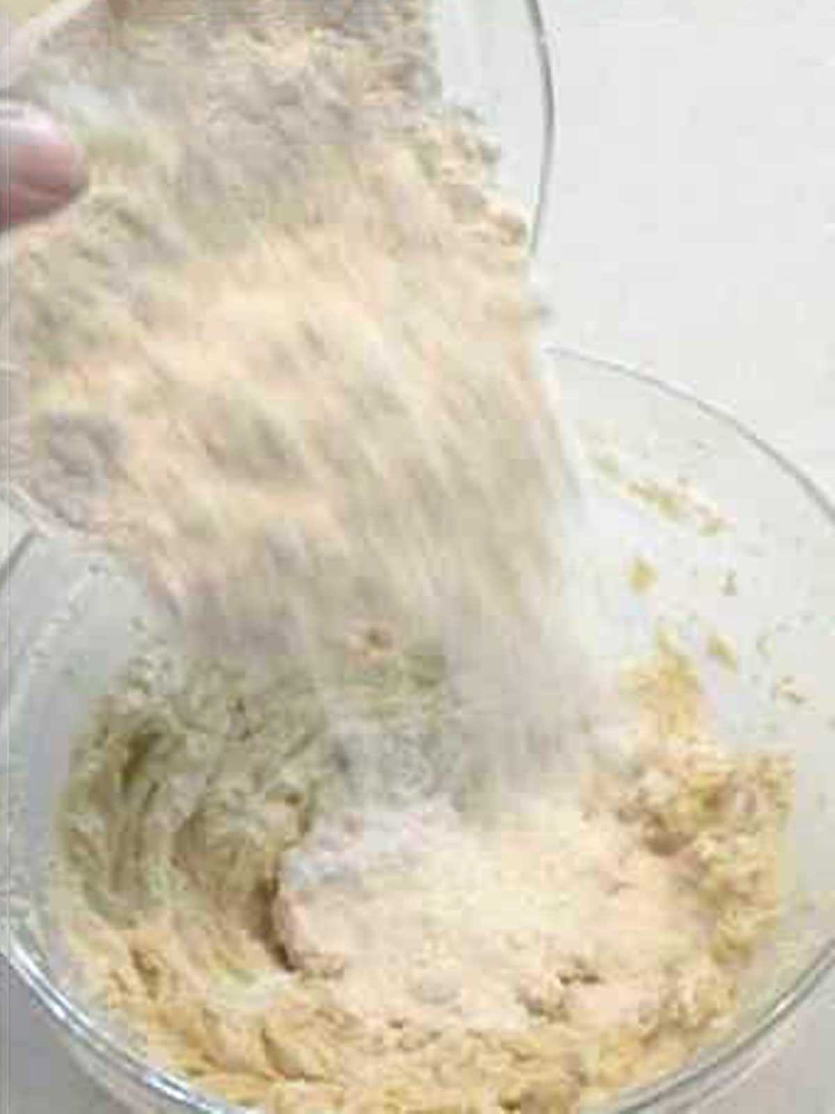 Adding flour to the cookie dough.