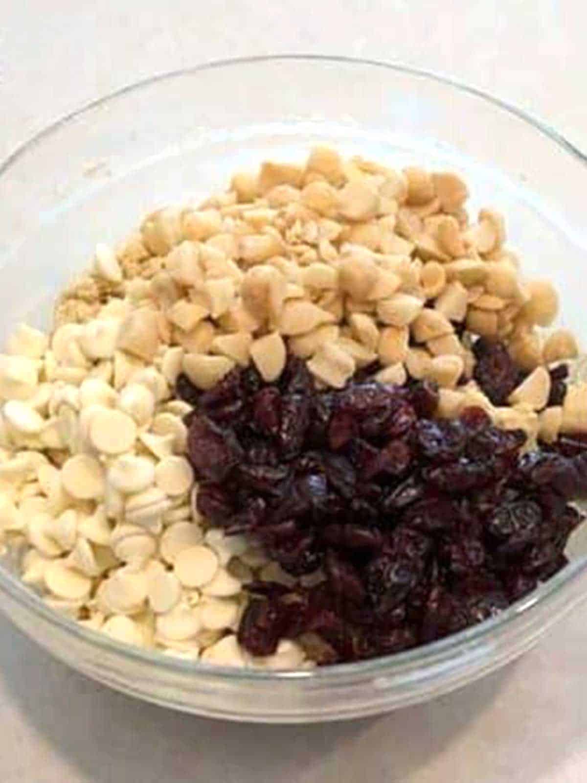 Craisins, white chocolate chips, and macadamia nuts in cookie dough.